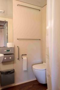 a bathroom with a white toilet and a sink at Camping De Kooiplaats in Schiermonnikoog