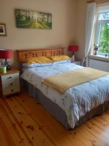 a bedroom with a bed with a blue comforter at Waterways Lodge in Carrick on Shannon