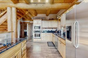 a kitchen with white appliances and wooden ceilings at Mogul Hill Cabin in Sandpoint