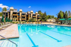 ein großes Schwimmbecken mit Liegestühlen und ein Gebäude in der Unterkunft Sun & Ski in Sun Valley