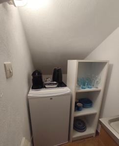 a small white refrigerator in a room with a shelf at ENDLESS BLUE Milos in Provatas +3 photos