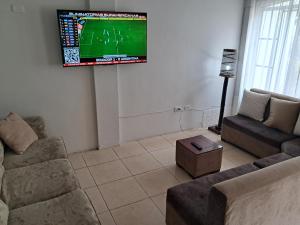 a living room with a flat screen tv on the wall at Roxel Home in Baños