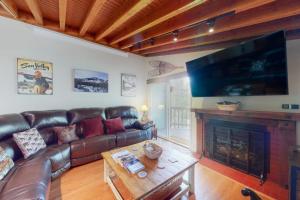 a living room with a leather couch and a fireplace at Valley Perch in Sun Valley