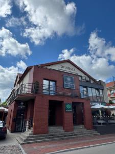 a red brick building on the corner of a street at Sauna Dharma Stay Self check in in Telšiai