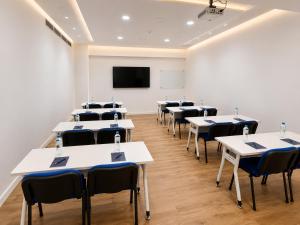 a room with tables and chairs and a projection screen at Hotel Mio Panamá in Panama City