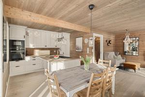 a kitchen and dining room with a table and chairs at Cozy and modern cabin in Vossevangen