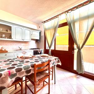 a kitchen with a table with chairs and a table and a kitchen at White House Quartu in Quartu SantʼElena