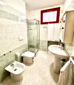 a bathroom with a sink and a toilet and a shower at White House Quartu in Quartu SantʼElena +10 photos