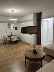 a living room with a kitchen and a table at Apartman Rawda in Jajce