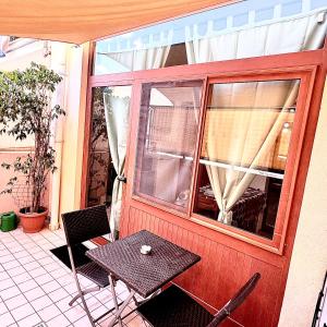 a patio with a table and chairs and a window at White House Quartu in Quartu SantʼElena