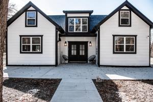 a white house with a black door at Made with Love in Thackerville