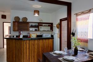 a kitchen with a counter and a table with plates on it at Mareias Villas in São Miguel do Gostoso