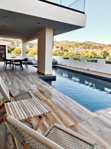 an outdoor deck with chairs and a swimming pool at Aura Mare in Porto Rafti