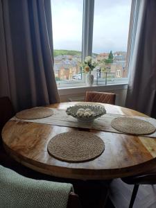 a wooden table with chairs and a bowl of flowers on it at Number 47 in Hawick
