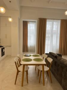 a living room with a table and chairs and a couch at Студія біля Прикордонної Академії in Khmelnytskyi +9 photos