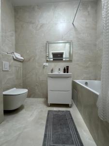 a bathroom with a tub and a toilet and a sink at Студія біля Прикордонної Академії in Khmelnytskyi