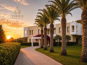 a row of palm trees in front of a building at Themis Luxury Private Villa Rhodes with Private Pool in Ialysos