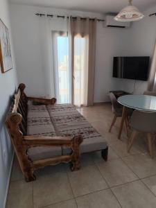 a room with a chair and a table and a television at NaxosChoraNext in Galanádhon