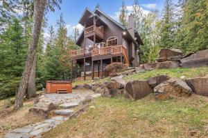 a large wooden house on a hill with trees at Riverfront Retreat in Sagle