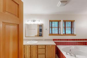 a bathroom with a tub and a sink and a mirror at Riverfront Retreat in Sagle +62 photos