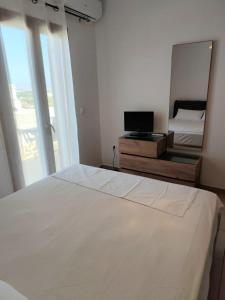 a bedroom with a large white bed and a mirror at NaxosChoraNext in Galanádhon