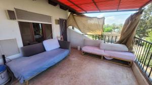 a living room with two couches and a balcony at Shaked בית שקד in Moshav Ramot