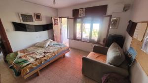 a bedroom with a bed and a couch in it at Shaked בית שקד in Moshav Ramot +21 photos