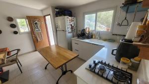 a kitchen with a refrigerator and a counter top at Shaked בית שקד in Moshav Ramot
