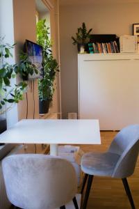 a white table and two chairs in a room with plants at Green Balcony Studio near Metro in Norsborg