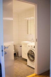 a bathroom with a washing machine and a sink at Green Balcony Studio near Metro in Norsborg
