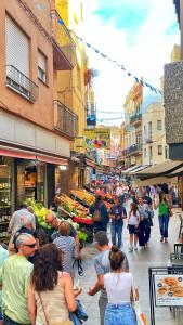 a group of people walking around a market in a city at NEW - Casa Palamós - Charming historical home with patio, in the heart of the old town, 100m from beach in Palamós