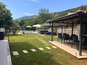 a patio with chairs and a pavilion in a yard at Villa Riviera blue with seaview, pool, whirlpool, parking and boat excursions in Opric