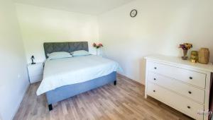 a bedroom with a bed and a dresser at Villa Amor in Mostar