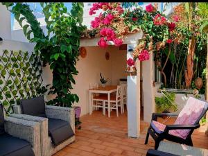 a patio with flowers and a table and chairs at Casa Rustica - Entire Courtyard House - Sunny Patio in Olhão