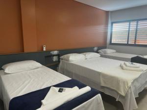 a hospital room with two beds and a window at Prime Pousada - Posto Sudoeste Queimadas in Queimadas