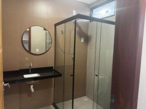 a bathroom with a shower and a sink and a mirror at Prime Pousada - Posto Sudoeste Queimadas in Queimadas +9 photos