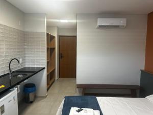 a bathroom with a bed and a sink in a room at Prime Pousada - Posto Sudoeste Queimadas in Queimadas