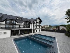 a house with a swimming pool in front of a building at Edelweiss New 2026 Солотвино in Solotvyno