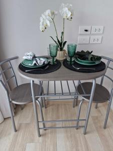 a dining room table with green plates and a vase of flowers at Serenity Naiyang Най Янг D02 in Nai Yang Beach