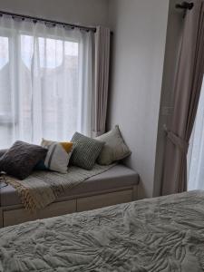 a bedroom with a bed with pillows and a window at Serenity Naiyang Най Янг D02 in Nai Yang Beach +34 photos
