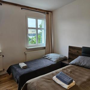 a bedroom with two beds and a window at Kamienica Nowodworska 30 in Bydgoszcz