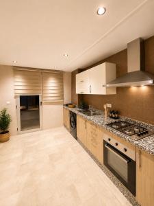 a large kitchen with wooden cabinets and a stove at Residence vigier in Tangier +15 photos