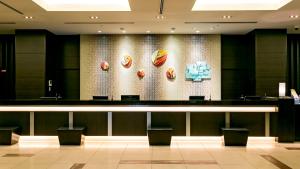 a bar in a restaurant with a wall with food on it at Holiday Inn Osaka Namba by IHG in Osaka