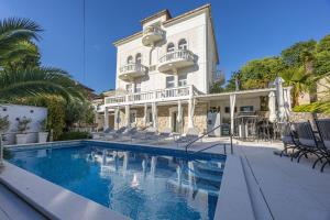 a hotel with a swimming pool in front of a building at Villa Vita luxury Apartments in Crikvenica