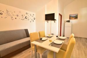a dining room with a table and chairs and a couch at Villa Natali in Pridraga