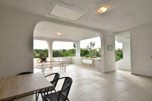 a living room with tables and chairs and windows at Villa Natali in Pridraga