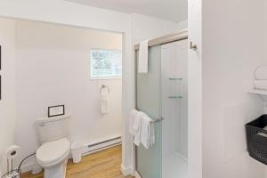 a white bathroom with a toilet and a shower at The River House in Sandpoint +75 photos