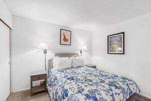 a bedroom with a bed with a blue and white comforter at Valley Gem Lower in Sun Valley +52 photos