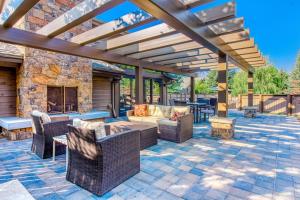 an outdoor patio with wicker furniture and a fireplace at Sanctuary on Snow Creek in Sun Valley