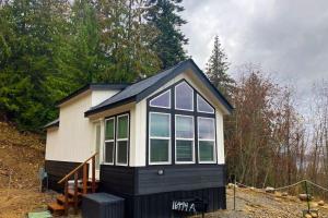 a black and white tiny house in the woods at Tiny Lake Retreat in Sagle